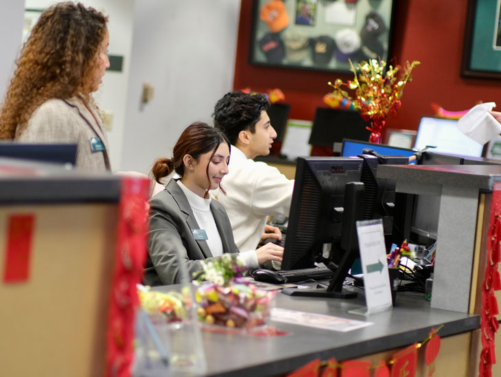 students working at the front desk in the  Programs office